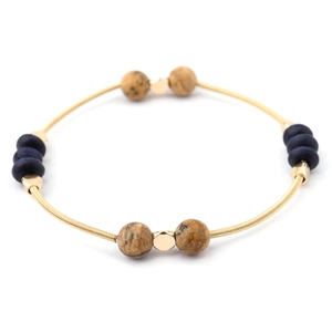 Detail of bohemian gold wire bracelet with navy wood beads and spotted natural stones