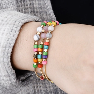 Pulsera dorada de tres capas con cuentas de madera coloridas y piedras naturales