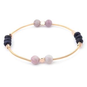Detail view of gold spring wire bracelet with pink stone and blue frosted beads