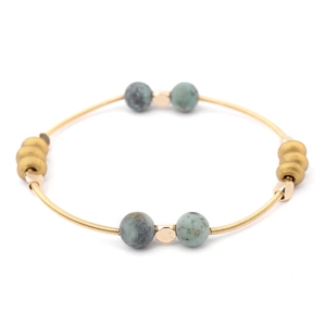 Detail of spiral gold wire bracelet with turquoise beads and hexagonal spacers