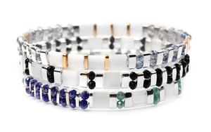 Close-up of colorful Miyuki Tila bead bracelets with metallic spacers and crystals