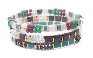 Detail of layered Miyuki Tila stretch bracelets with turquoise, purple and gold beads