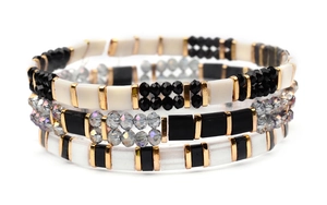 Macro detail of multilayer handmade Miyuki Tila beaded bracelet set in black and gold