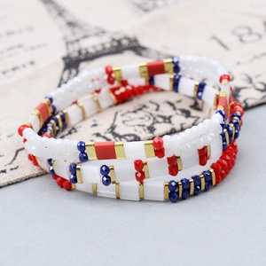 Detail of layered Miyuki Tila bead bracelets with French flag red white blue colors