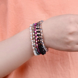 Close-up of multilayer beaded bracelet set with crystal cut beads on a female model wrist