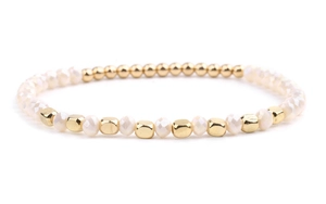 Close-up of golden metallic beads and faceted milky white crystal beads on a handmade bracelet