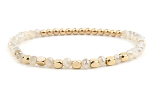 Close-up of DIY beaded bracelet with golden metallic beads and faceted white resin gems