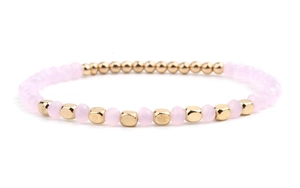 Detail of pink crystal beads and golden geometric metal beads on an elastic bracelet