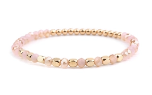 Detail of pink crystal beads and golden geometric metal spacers on a stretch bracelet