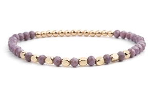 Detailed macro view of purple faceted crystal beads and golden metallic beads on the bracelet