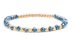 Detail of DIY beaded crystal bracelet with blue faceted beads and golden metal accents