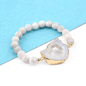 Vue macro du bracelet en perles de pierre blanche avec tranche d'agate à bord doré