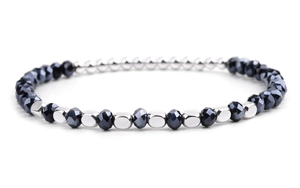 Close-up of faceted black beads and silver metal spacers on a handmade bracelet