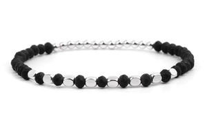 Detail of faceted black stones and polished silver beads on a modern beaded bracelet