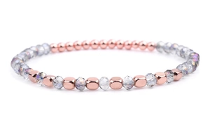 Detail of rose gold metal cubes and faceted crystal beads on an elegant beaded bracelet