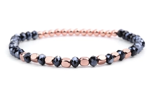 Detail of beaded bracelet with dark grey faceted crystals and rose gold geometric metallic beads
