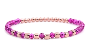 Close-up of rose gold geometric beads and vibrant rose red faceted crystal beads on bracelet