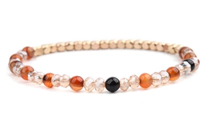 Dettaglio del bracciale elastico con perline di agata arancione e accenti dorati
