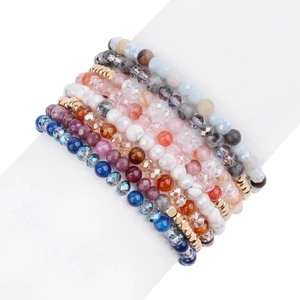 Set di braccialetti bohémien con perline in pietra naturale e dettagli dorati su supporto