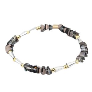 Dettaglio di perle in cristallo irregolari e sfere dorate su questo bracciale da donna