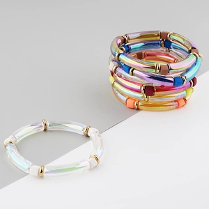 Detailed macro view of colorful iridescent acrylic curved tube bracelets with gold spacers