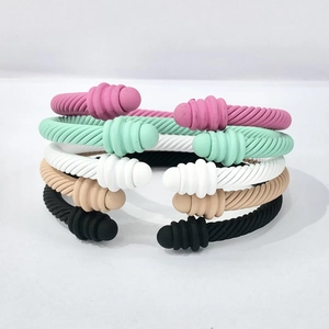 Detailed stack of five colorful matte cable bracelets in pink, green, white, and black tones