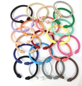 Close-up of twisted cable cuff bracelets in colorful matte finishes and metallic tones