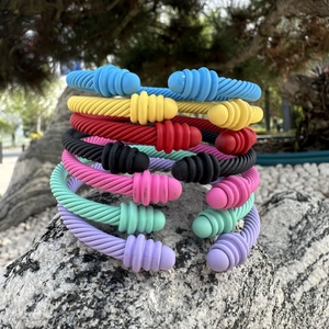 Set of seven colorful cable twist open bangles on grey stone with matte finish
