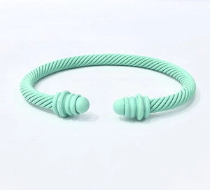 Detailed top view of mint green matte twisted cable open bangle with spherical ends