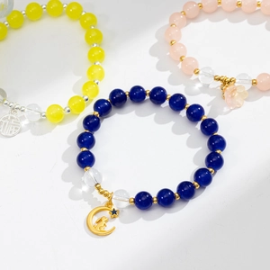 Dettaglio macro di braccialetti con perline colorate e ciondoli a forma di fiore e coniglio