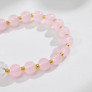 Dettaglio macro del bracciale mughetto con perline di cristallo rosa e distanziatori dorati