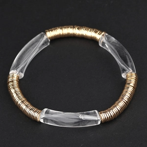 Gros plan de disques métalliques dorés et de perles acryliques courbées sur un bracelet perlé