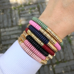 Detalle de pulseras bohemias multicapa con cuentas de colores en la muñeca de una mujer