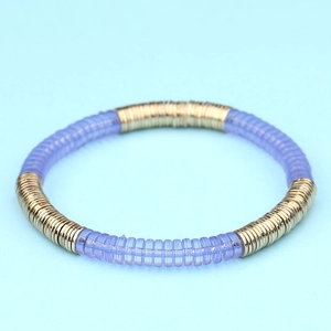 Detalle de una pulsera elástica bohemia con cuentas planas de color púrpura y oro