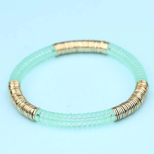 Detalle de la pulsera bohemia colorida con discos de acrílico dorados y verdes