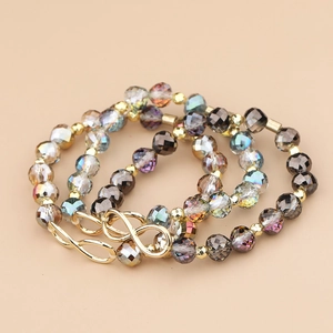 Drielagige infinity kralenarmband met grijze kristallen en gouden accenten