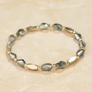Detailed macro view of gray-green faceted crystal beads and golden metallic accents