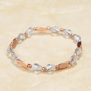 Detail of beaded bracelet with faceted clear crystals and rose gold metal spacers