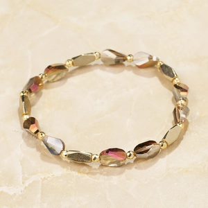 Close-up of beaded bracelet with iridescent olive crystal glass and gold hexagonal beads