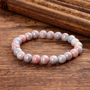 Détail de perles en verre de cristal rose et bleu sur fond bois avec décor bambou