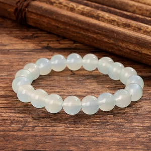 Élégant bracelet en perles de verre cristal bleu clair sur fond de bois rustique