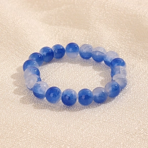 Vue détaillée des perles de 10 mm avec dégradé bleu et blanc sur un fond en tissu texturé