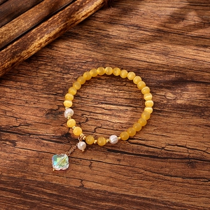 Detail of yellow cat eye stone beads with white freshwater pearls and crystal clover charm