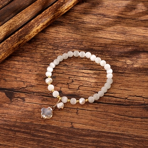 Elegant cat eye stone and freshwater pearl bracelet with a crystal clover charm