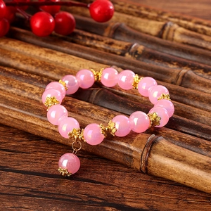 Detail von rosa Kristallperlenarmband mit goldenen Blumen-Zwischenstücken und Anhänger