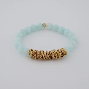 Detailed macro view of light blue beaded bracelet with gold metal rings and clusters