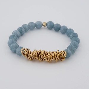 Detailed view of blue natural stone beaded bracelet with textured gold metal rings