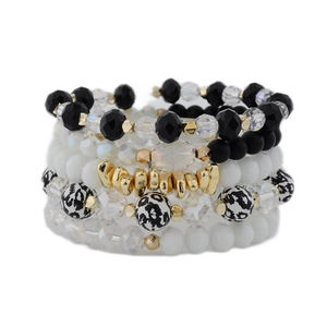 Detail eines mehrlagigen Perlenarmband-Sets mit Leopardenmuster und goldenem Anhänger
