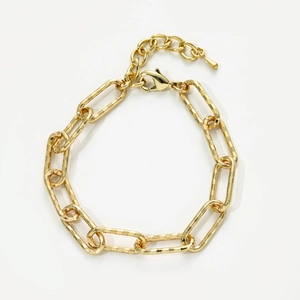 Close-up of gold chunky oval link chain anklet with lobster clasp and teardrop charm