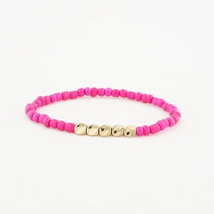 Détail des perles roses mates et accents dorés sur le bracelet élastique fait à la main